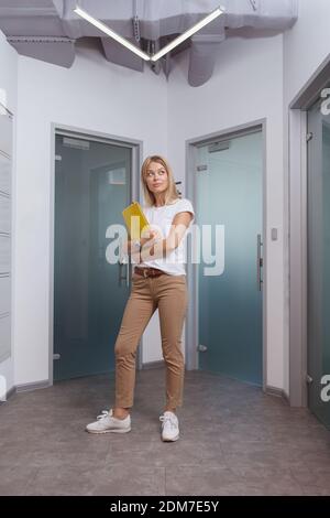 Foto verticale a lunghezza intera di una bella giovane imprenditore in un ambiente di lavoro moderno Foto Stock