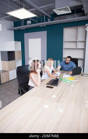 Immagine verticale di un gruppo di imprenditori che lavorano a moderno area di lavoro Foto Stock