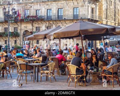 Locals and tourists relax and enjoy some drink and meal in the Main Square (Plaza Mayor) - Leon, Castile and Leon, Spain Stock Photo