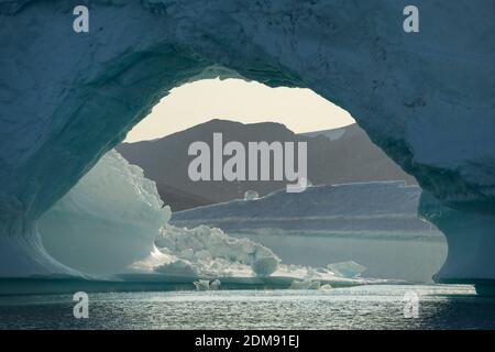 Vista attraverso l'arco in grande iceberg, Sermilik Fjord, Groenlandia orientale Foto Stock