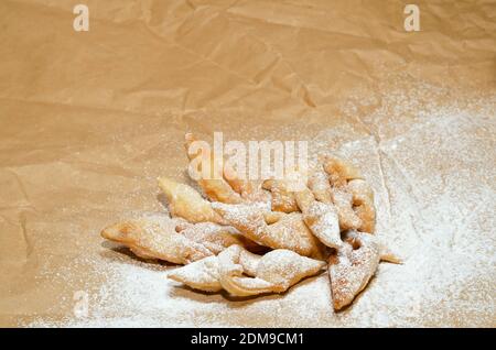 I biscotti spazzolati di legno spolverati con zucchero in polvere, si trovano su carta sminuzzata Foto Stock