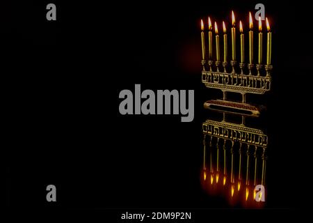 Menorah with burning candles with reflection for Hanukkah jewish holiday. Foto Stock