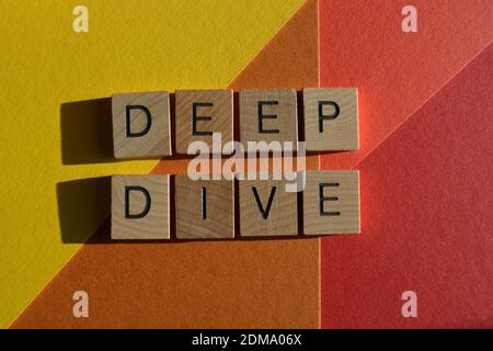 Immersione profonda, parole in lettere alfabetiche in legno isolate su sfondo colorato Foto Stock
