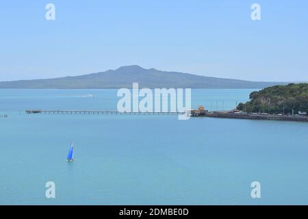 Vista del Molo della Baia di Okahu e del Ponte con Vista Mare Tamaki Drive con Rangitoto dormiente vulcano isola in background Foto Stock