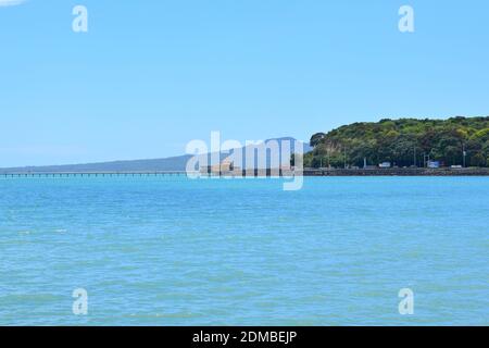 Vista del Molo della Baia di Okahu e del Ponte con Vista Mare Tamaki Drive con Rangitoto dormiente vulcano isola in background Foto Stock