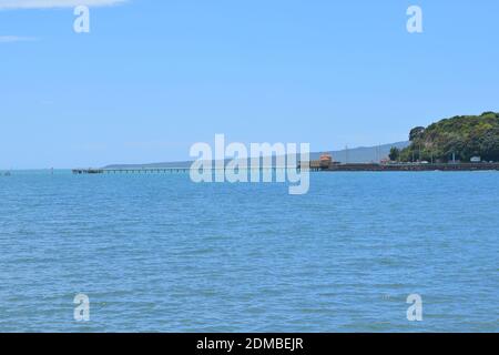 Vista del Molo della Baia di Okahu e del Ponte con Vista Mare Tamaki Drive con Rangitoto dormiente vulcano isola in background Foto Stock