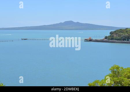 Vista del Molo della Baia di Okahu e del Ponte con Vista Mare Tamaki Drive con Rangitoto dormiente vulcano isola in background Foto Stock