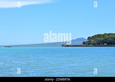 Vista del Molo della Baia di Okahu e del Ponte con Vista Mare Tamaki Drive con Rangitoto dormiente vulcano isola in background Foto Stock