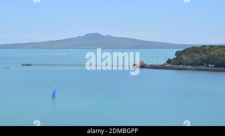 Vista del Molo della Baia di Okahu e del Ponte con Vista Mare Tamaki Drive con Rangitoto dormiente vulcano isola in background Foto Stock