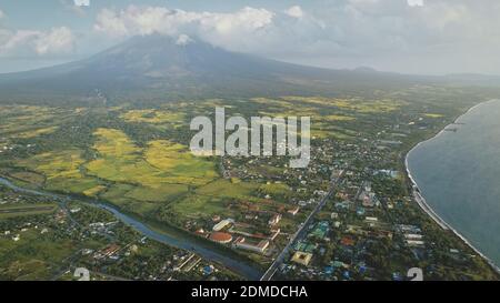 Paesaggio urbano tropicale a mare baia fiume rive aeree. Strade con cottage e logge con strada del traffico. Valle verde a Mayon vulcano Legazpi città, Filippine. Nessuno paesaggio naturale a nebbia foschia Foto Stock