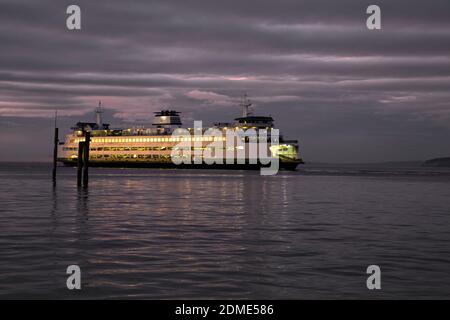WA18771-00...WASHINGTON - Ferry leaving the dock in Edmonds at sunset and heading across the Puget Sound to Kingston. Foto Stock
