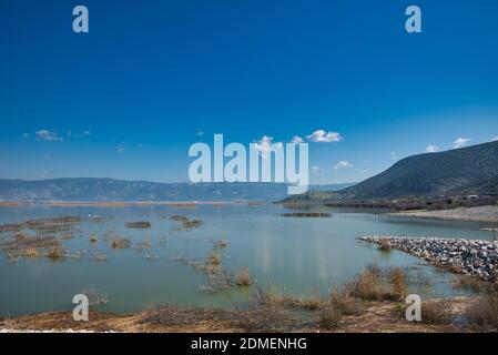 A majestic cloudscape over a calm Karla lake in Greece during the daytime Stock Photo