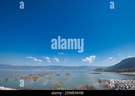 A majestic cloudscape over a calm Karla lake in Greece during the daytime Stock Photo