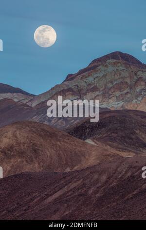 Luna piena che sorge su Artists palette, Death Valley National Park, California Foto Stock