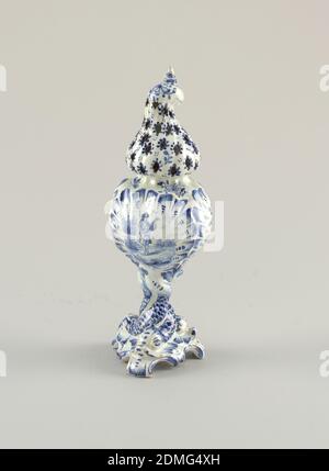 caster, terracotta, smalto, base a chiocciola di 6 piedi, gambo formato da 3 delfini ritorti; corpo a conchiglia a 3 lati; sommità a cappuccio ritorto con fori forati, sormontata da una piccola finiale a spirale; Dipinto in blu scuro su bianco con delfini sul gambo, uomo con violino su un pannello laterale, motivi floreali e a foglia, Delft, Paesi Bassi, 1875–1900, ceramica, arti decorative, caster Foto Stock