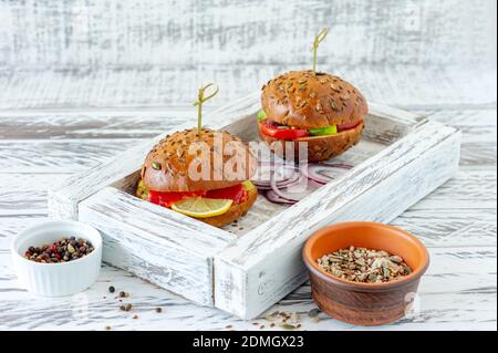 panino intero farcito con insalata, salmone, avocado e pomodori. Concetto di cibo sano. Foto Stock