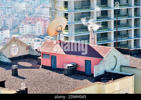 Tetto piano o tetto di un edificio residenziale con un uscita cottage e antenna parabolica Foto Stock