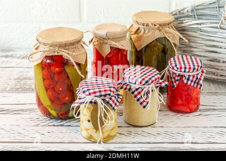 Varietà di sottaceti marinati che conservano i vasi. Pomodori fatti in casa, cetrioli, aglio, zenzero e sottaceti di rafano. Cibo fermentato Foto Stock