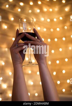 Donna mano che tiene il bicchiere di vino rosso