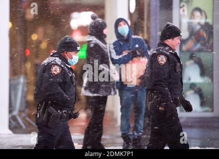 New York, Stati Uniti. 16 Dic 2020. I poliziotti camminano su Times Square a New York, Stati Uniti, 16 dicembre 2020. Una tempesta di neve ha colpito New York mercoledì. Credit: Wang Ying/Xinhua/Alamy Live News Foto Stock
