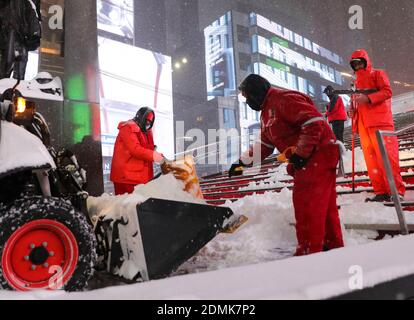 New York, Stati Uniti. 16 Dic 2020. Gli operatori sanitari puliscono la neve su Times Square a New York, Stati Uniti, 16 dicembre 2020. Una tempesta di neve ha colpito New York mercoledì. Credit: Wang Ying/Xinhua/Alamy Live News Foto Stock