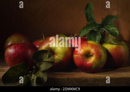 mele alla rinfusa. Ancora vita con mele mature su sfondo di legno in stile rustico Foto Stock