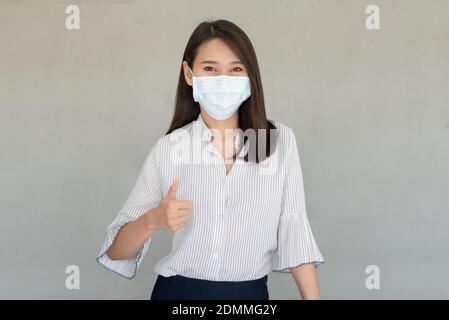 I dipendenti aziendali che indossano la maschera durante il lavoro in ufficio da tenere Igiene seguire Company policy.Preventive durante il periodo di epidemia da coronavirus Foto Stock