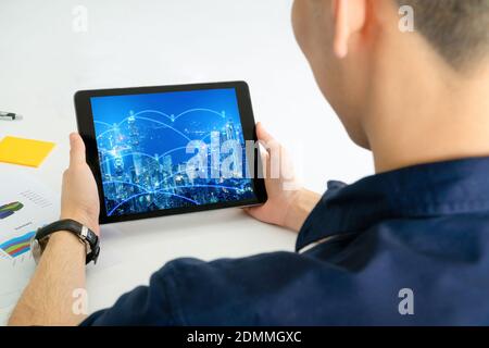 Back view of Business man using tablet for internet of thing network and big data system. Stock Photo