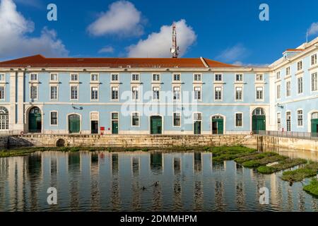 Lisbona, Portogallo - 15 dicembre 2020: Edificio con pareti blu e bianche e porte verdi riflesse in un laghetto tranquillo in primo piano Foto Stock