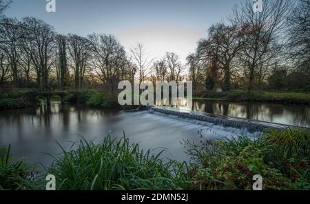 Merton, London, UK. 17 December 2020. Clear sky and mild temperatures at dawn in south west London, only 8 days before Christmas Day, with the River Wandle crossing a weir in Morden Hall Park. Credit: Malcolm Park/Alamy Live News. Stock Photo