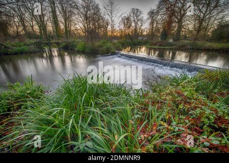 Merton, London, UK. 17 December 2020. Clear sky and mild temperatures at dawn in south west London, only 8 days before Christmas Day, with the River Wandle crossing a weir in Morden Hall Park. Credit: Malcolm Park/Alamy Live News. Stock Photo