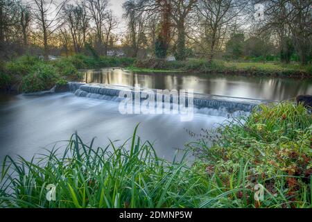 Merton, London, UK. 17 December 2020. Clear sky and mild temperatures at dawn in south west London, only 8 days before Christmas Day, with the River Wandle crossing a weir in Morden Hall Park. Credit: Malcolm Park/Alamy Live News. Stock Photo