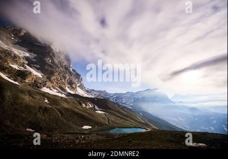 Paesaggio mozzafiato di cielo blu nuvoloso, bella zona di montagna con neve e piccolo lago blu chiaro. Splendida cresta di montagna con alte vette rocciose nelle Alpi, paese delle meraviglie. Cervino Foto Stock