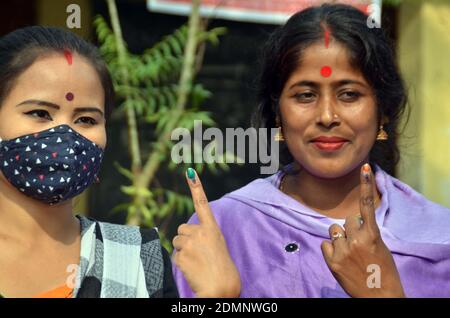 Nagaon, Assam, India - 17  December 2020: Two female voters shows her marks on fingers after casting their votes at a Polling station during the Tiwa Autonomous Council election in Kachamari village in Nagaon district of Assam, India on Thursday.  Credit: DIGANTA TALUKDAR/Alamy Live News Stock Photo