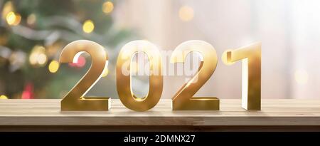 Bright golden 2021 numbers on wood table top with christmas tree light bokeh in banner background Stock Photo