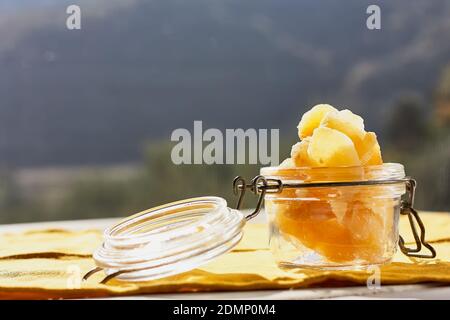Fette di zenzero candito in un vaso di vetro sul tavolo su sfondo naturale. Frutta orientale disidratata. Dolci sani. Antiossidanti. Foto Stock