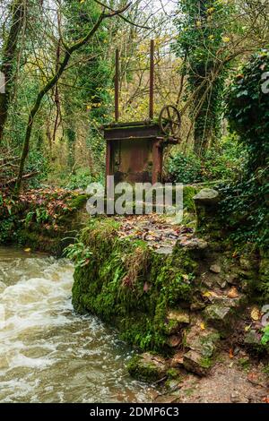 Old Sluice gate on the river, at the abandoned Fussells iron works in Mells, Somerset, Uk Stock Photo