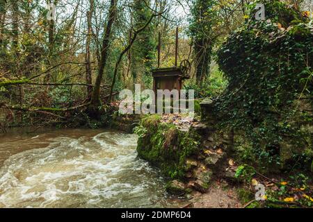 Old Sluice gate on the river, at the abandoned Fussells iron works in Mells, Somerset, Uk Stock Photo