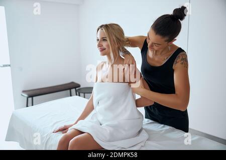 Fisioterapista professionista che effettua massaggi sulle spalle in medicina moderna clinica Foto Stock
