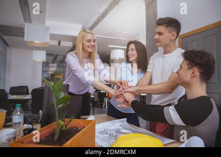 Lavoro di squadra, successo, concetto di unità. Gruppo di giovani imprenditori che mettono le mani insieme. Team aziendale che mostra l'unità con le mani insieme, co Foto Stock