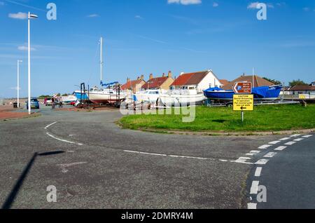 Meols, The Wirral, Regno Unito: 23 giugno 2020: Un cartello con le informazioni sul parcheggio per i visitatori del North Wirral Coastal Park accanto alle barche che riposano sul sentiero Foto Stock