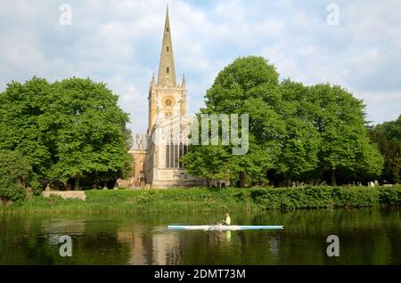 Rower sul fiume Avon Rowing passato la chiesa sepolcrale di Shakespeare, la chiesa commemorativa o la chiesa della Santa Trinità Stratford-upon-Avon Warwickshire Inghilterra Foto Stock