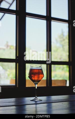 Un bicchiere di vino si trova di fronte ad una grande finestra da vicino. Vista dall'alto. Foto Stock