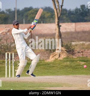 New Delhi India – 3 marzo 2020 : lunghezza completa del gioco del cricket sul campo durante la giornata di sole nel parco giochi locale, Cricketer sul campo in azione, Pla Foto Stock