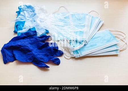 maschere facciali e guanti di protezione monouso blu sulla luce tavolo marrone Foto Stock