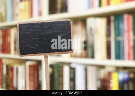 Etichetta lavagna vuota e libreria sfocata sullo sfondo. Risorse grafiche Foto Stock