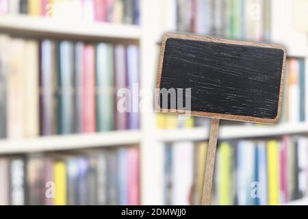 Etichetta lavagna vuota e libreria sfocata sullo sfondo. Risorse grafiche Foto Stock