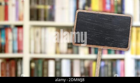 Etichetta lavagna vuota e libreria sfocata sullo sfondo. Risorse grafiche Foto Stock