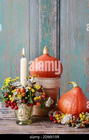 Portacandele d'autunno decorato con rosa, bacche di biancospino e tansy. Decorazioni per feste Foto Stock