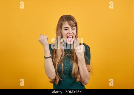 Balli felici, fare onda, divertirsi, ascoltare musica, sorridere. Mani agitanti graziate. Balli, salta, gioisce, ride. Braccia, femmina bella giovane attraente sensazione emozionale di salto eccitato Foto Stock